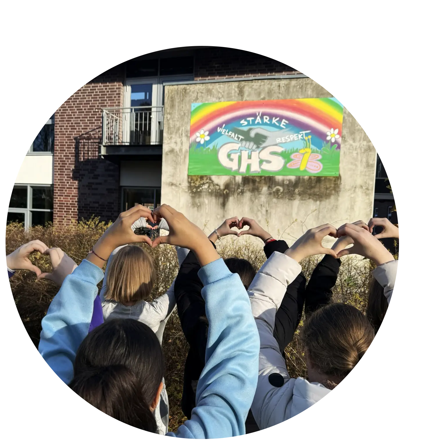 Schüler der Hauptschule Hückelhoven zeigen Herzen mit ihren Händen vor dem Logo der GHS